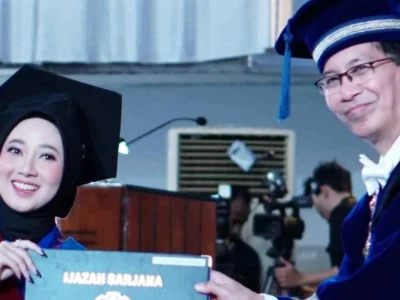 Wisudawan penyandang tunarungu, Nadya Andini, saat menerima ijazah dari Rektor ITS Prof Dr Ir Mochamad Ashari MEng saat prosesi Wisuda ke-129. Foto : Humas ITS