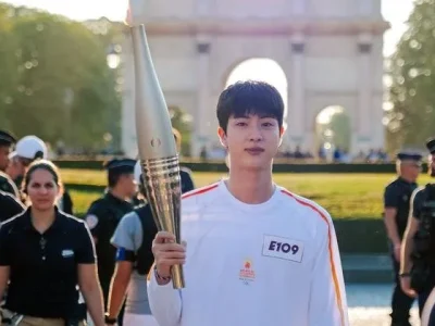 Kim Seokjin atau Jin BTS membawa obor Olimpiade Paris pada Ahad, 14 Juli 2024. Foto: X/Paris2024