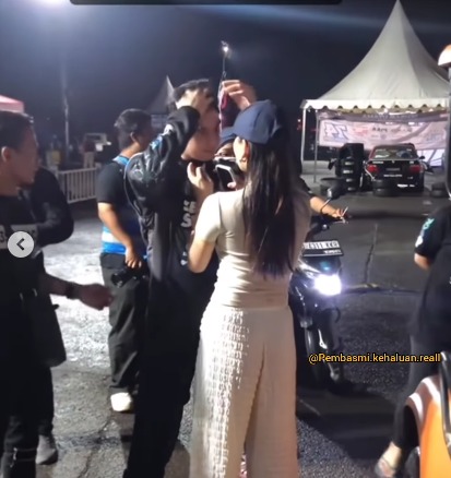 Alyssa tampak merapikan pakaian Al Ghazali di ajang kejuaraan drifting nasional D1 Grand Prix Indonesia. (Foto: Instagram/lambegosip)