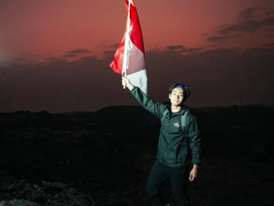 Jeremy Owen mengibarkan bendera RI di gunungan sampah Bantar Gebang, Bekasi agar masyarakat semakin menyadari perlunya pengolahan sampah. (Foto: dokpri)