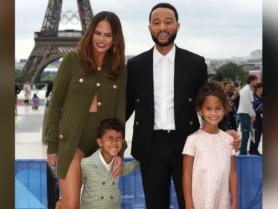 Miles, anak kedua John Legend mengenakan setelan jas hijau berdiri di depan ibunya. Foto: Dok. Instagram @chrissyteigen