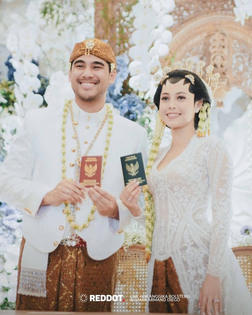 Anggika dan Omar berfoto dengan buku nikah setelah proses akad nikah (foto: Instagram/reddot.livestream)