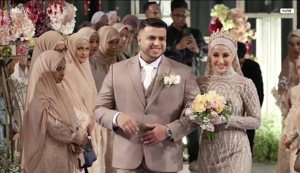 Kedua mempelai berjalan bersama ke pelaminan (Foto: YouTube/Fadil)