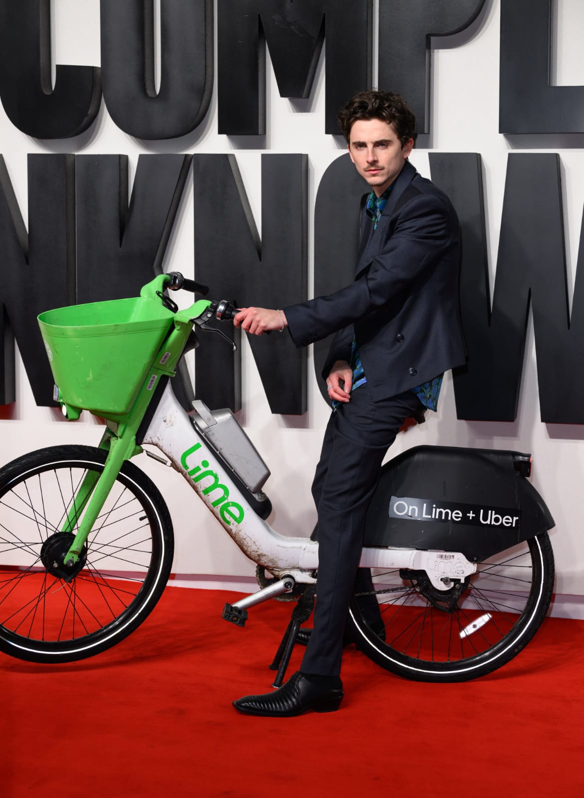 Timothee Chalamet berpose sambil tetap duduk di sepeda listriknya. Foto: Dok. X @THR