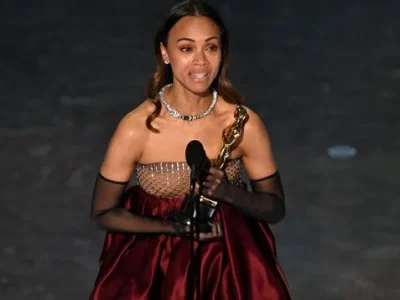 Zoe Saldana menerima penghargaan Oscar 2025. Foto: Patrick T. Fallon/AFP