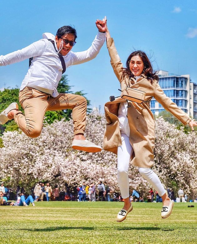 Andre Taulany dan istri berpose dengan latar belakang bunga sakura. Foto : Instagram/andreastaulany