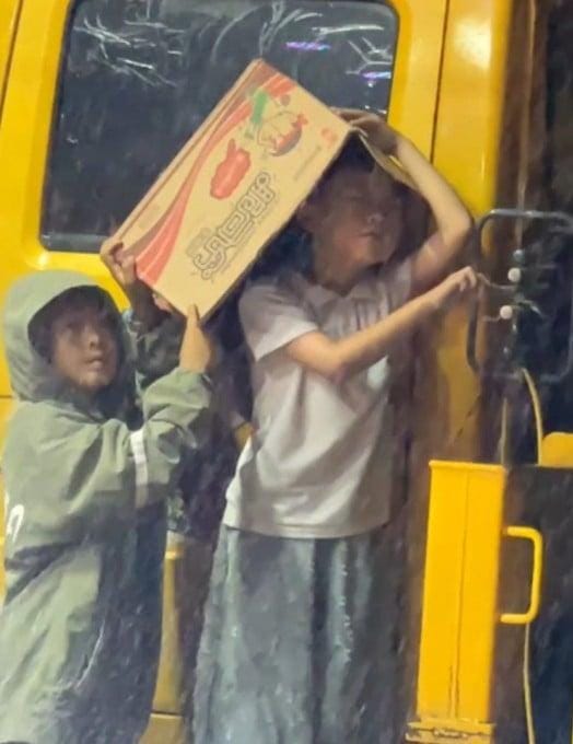 Xie Yule diberi kardus untuk dijadikan payung. Foto: Dok. SCMP
