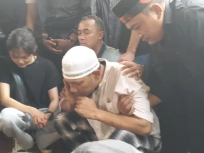 Suami Mpok Alpa, Ajie Darmaji di samping liang lahad. (Foto: Bayu/Nyata)