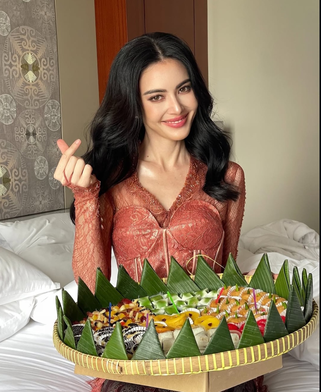 Davika mengenakan kebaya pink dan membawa jajanan pasar. Foto: Dok. Instagram @davikah